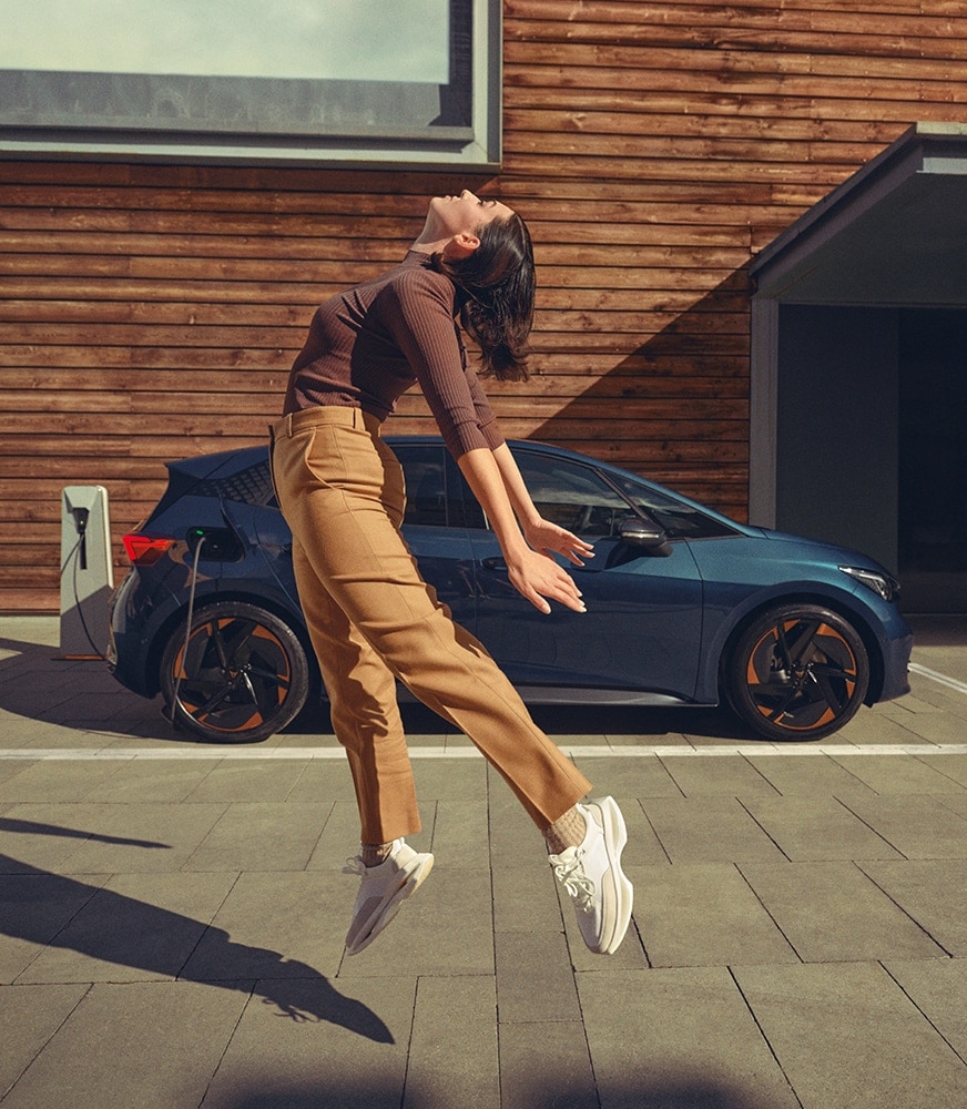 %20woman-jumping-cupra-Born-aurora-blue-colour-charging